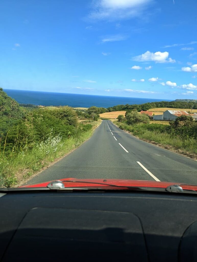 Driving road view of Robin Hood’s Bay on a sunny summers day on the North Yorkshire coast.