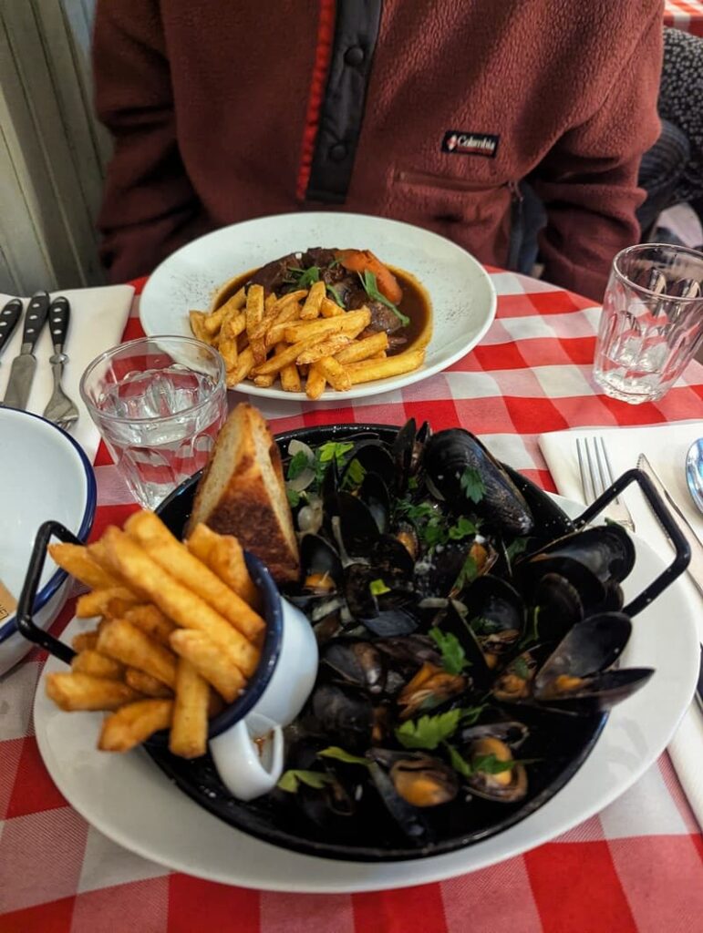 Mussels and beef bourguignon on a checkered red table in Ostebutikken, Grunerlokka, Oslo, Norway